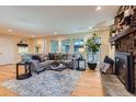 Inviting living room with hardwood floors, a stone fireplace, and multiple windows offering outdoor views at 26732 Main St, Conifer, CO 80433