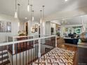 Beautiful foyer with hardwood floors and modern light fixtures leading to the living room at 6405 Warriors Run, Littleton, CO 80125