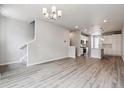 Open-concept living room featuring wood floors, modern lighting, stairs to the upper level, and view of kitchen area at 451 Interlocken Blvd # 104, Broomfield, CO 80021