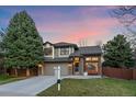 Charming two-story home featuring a brick facade, well-manicured lawn, and a welcoming porch swing at 10240 Travertine Pl, Parker, CO 80134