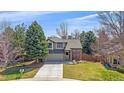 Charming two-story home featuring a brick facade, well-manicured lawn, and a welcoming porch swing at 10240 Travertine Pl, Parker, CO 80134