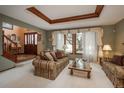 Comfortable living room featuring plush seating, large windows, and coffered ceiling at 7965 S Eudora Cir, Centennial, CO 80122