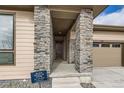 Inviting covered entryway featuring stone columns and a modern front door, offering a quick move-in ready home at 454 Basin Daisy St, Castle Rock, CO 80104