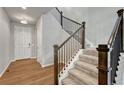 Elegant staircase with wooden banister, leading from a hardwood-floored entry, to upper levels at 15902 Stringhalt Way, Parker, CO 80134