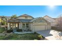 Charming home exterior with stone accents, a three-car garage, and lovely landscaping at 1660 Moveen Hts, Monument, CO 80132