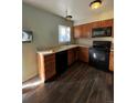 Galley-style kitchen with wood cabinets and modern appliances at 16786 E Kent Dr, Aurora, CO 80013