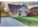 Inviting home featuring a well-manicured lawn, concrete driveway, brick facade, and tasteful exterior accents at 3745 Fairfax St, Denver, CO 80207
