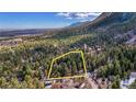 This aerial view shows the property boundary outlined in yellow with surrounding lush forest at 4835 Abo Ln, Monument, CO 80132