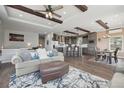 Open-concept living room featuring wood beams, hardwood floors, a kitchen island with bar seating, and modern decor at 1729 Santa Fe Mountain Rd, Evergreen, CO 80439