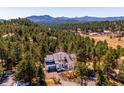 Stunning aerial view of home nestled among the trees, with mountain views in the background, offering privacy at 2122 Cramner Ct, Evergreen, CO 80439