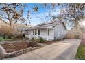 Charming home featuring a covered porch, solar panels, and a meticulously landscaped front yard at 1623 Dayton St, Aurora, CO 80010