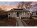 Charming home featuring a covered porch, solar panels, and a meticulously landscaped front yard at 1623 Dayton St, Aurora, CO 80010
