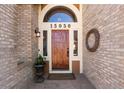 Elegant front door with arched window and stone surround at 15050 Harrison St, Brighton, CO 80602