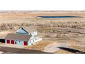 Aerial view of a two-story home, pond, and other buildings on the property at 52900 E 88Th Ave, Strasburg, CO 80136