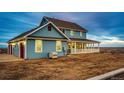 View of the back of the home with attached garage and large yard at 52900 E 88Th Ave, Strasburg, CO 80136