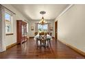 Elegant dining room featuring hardwood floors, large windows, and a stylish chandelier at 11784 Spruce Mountain Rd, Larkspur, CO 80118