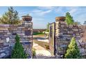 Charming stone gate with decorative accents leading to a serene outdoor space and landscaping at 11784 Spruce Mountain Rd, Larkspur, CO 80118