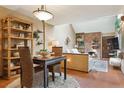 Cozy dining area showcases a dining table, attractive bamboo shelving, brick fireplace and seamless flow to the living room at 2783 W Long Dr # B, Littleton, CO 80120