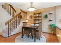 This dining area features a rustic wood dining table, comfortable seating, natural light, and is conveniently located by the stairs at 2783 W Long Dr # B, Littleton, CO 80120