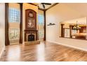 Inviting living room with tall windows, a stone fireplace, and hardwood floors at 9602 S Hackberry St, Highlands Ranch, CO 80129