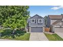 Beautiful two-story home with gray siding, stone accents, and a lush, green front yard at 5323 E Hamilton Ave, Castle Rock, CO 80104