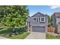 Beautiful two-story home with gray siding, stone accents, and a lush, green front yard at 5323 E Hamilton Ave, Castle Rock, CO 80104