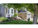 Inviting home exterior with manicured lawn, flower beds, and charming stone accents at 5323 E Hamilton Ave, Castle Rock, CO 80104