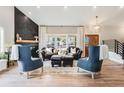 Elegant living room featuring a striking fireplace, large windows, and comfortable seating arrangement at 6242 W Lakeside Ct, Littleton, CO 80125