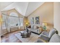 Bright living room with high vaulted ceilings, hardwood floors, and modern décor at 9443 Palisade Ct, Highlands Ranch, CO 80130