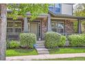 Inviting front porch with decorative pillars, brick accents, and well-maintained lawn and garden at 5892 W 94Th Pl, Westminster, CO 80031