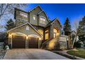 Charming stone and stucco home with a two-car garage and elegant lighting at 7120 Forest Ridge Cir, Castle Pines, CO 80108