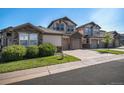 Well-manicured lawn and landscaping surround this two-story townhome at 23235 York Ave, Parker, CO 80138