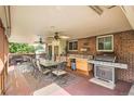 Spacious covered deck with ample seating, a large table, and an outdoor kitchen setup at 10223 W 77Th Dr, Arvada, CO 80005