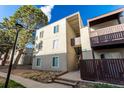 Building exterior featuring balconies, updated siding, and mature trees around the property at 9725 E Harvard Ave # 418, Denver, CO 80231
