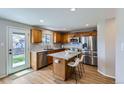 Well-lit kitchen featuring granite countertops, stainless steel appliances, and a kitchen island with seating at 4620 E 135Th Way, Thornton, CO 80241