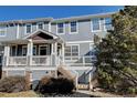 Gray townhome with a front porch, staircase, and landscaping at 9343 Amison Cir # 103, Parker, CO 80134