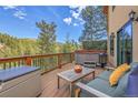 Relaxing deck featuring a hot tub, seating, and a serene mountain view, perfect for outdoor enjoyment at 5254 Cheyenne Rd, Indian Hills, CO 80454