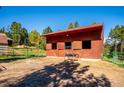 Barn featuring a red roof, fenced area and blue sky at 28553 Birch Ln, Conifer, CO 80433