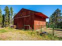 Exterior shot of a barn featuring a sliding door and fenced area at 28553 Birch Ln, Conifer, CO 80433