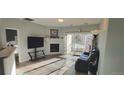 Cozy living room features a fireplace, wood floors, and sliding doors to a balcony at 7355 S Alkire St # 203, Littleton, CO 80127