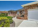View of the brick house exterior, showing the driveway, garden, and attached garage at 3810 Urban St, Wheat Ridge, CO 80033