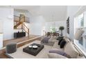 Bright living room showcasing an open layout with modern furniture, vaulted ceilings, and hardwood floors at 6054 W Adriatic Pl, Lakewood, CO 80227