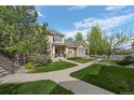Beautiful two-story home featuring a well-maintained lawn, stone accents, and inviting front porch with walkway at 5944 S Yank Ct, Littleton, CO 80127