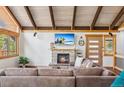 Cozy living room features a stone fireplace, beamed ceilings, and comfortable seating at 142 High Point Dr, Breckenridge, CO 80424