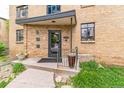 Inviting entrance to the unit, featuring a brick facade and well-maintained landscaping with garden plants at 1182 Clermont St # A202, Denver, CO 80220
