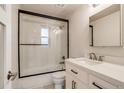 Modern bathroom featuring a shower over tub, a glass door and a sleek vanity with black hardware at 488 S Leyden St, Denver, CO 80224