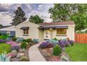 Beautifully landscaped front yard with a curved walkway leading to a charming brick home at 488 S Leyden St, Denver, CO 80224