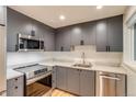 Modern kitchen with stainless steel appliances, sleek gray cabinets, and light countertops at 488 S Leyden St, Denver, CO 80224