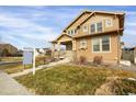 Tan two-story house with a covered porch and landscaped yard at 21719 E Tallkid Ave, Parker, CO 80138