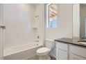 Clean bathroom featuring a shower-tub combo, a single sink, and white tiled walls at 2128 S Haleyville Way, Aurora, CO 80018